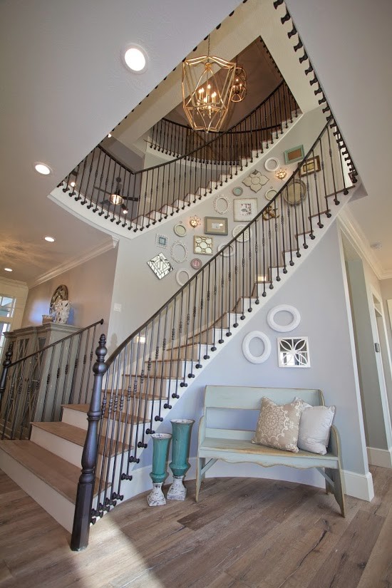 Inspiration for an expansive farmhouse wood curved staircase in Salt Lake City with wood risers and feature lighting.