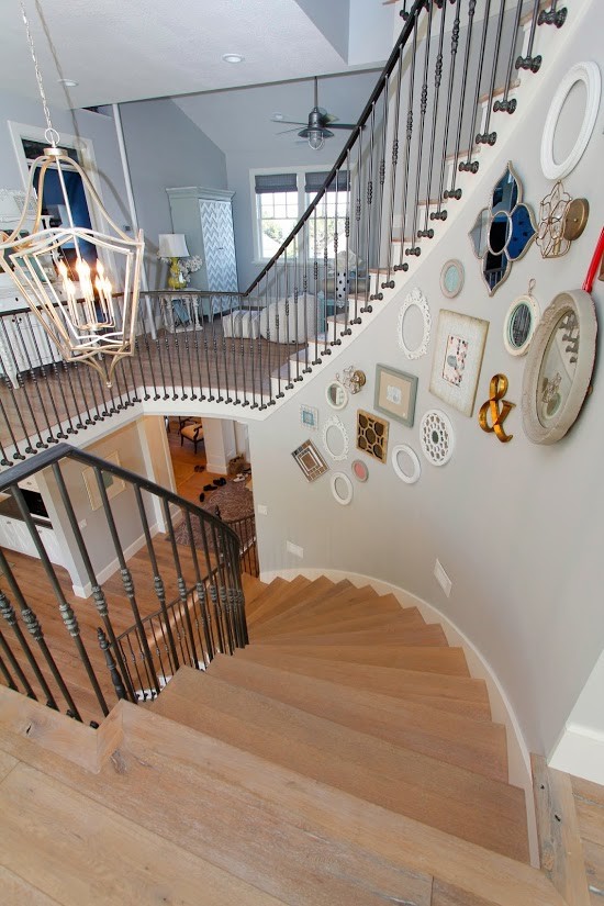 Photo of an expansive farmhouse wood curved staircase in Salt Lake City with wood risers.