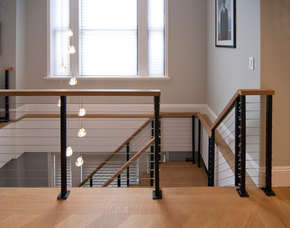 Imagen de escalera en U contemporánea grande sin contrahuella con escalones de madera y barandilla de cable