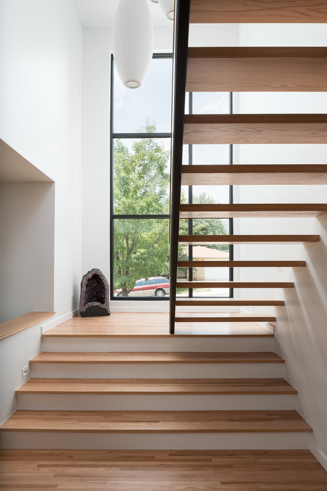 Imagen de escalera en U contemporánea de tamaño medio sin contrahuella con escalones de madera y barandilla de metal