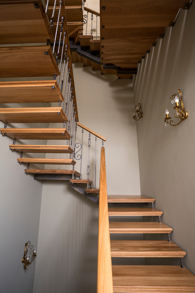 Ejemplo de escalera suspendida actual de tamaño medio con escalones de madera y contrahuellas de madera