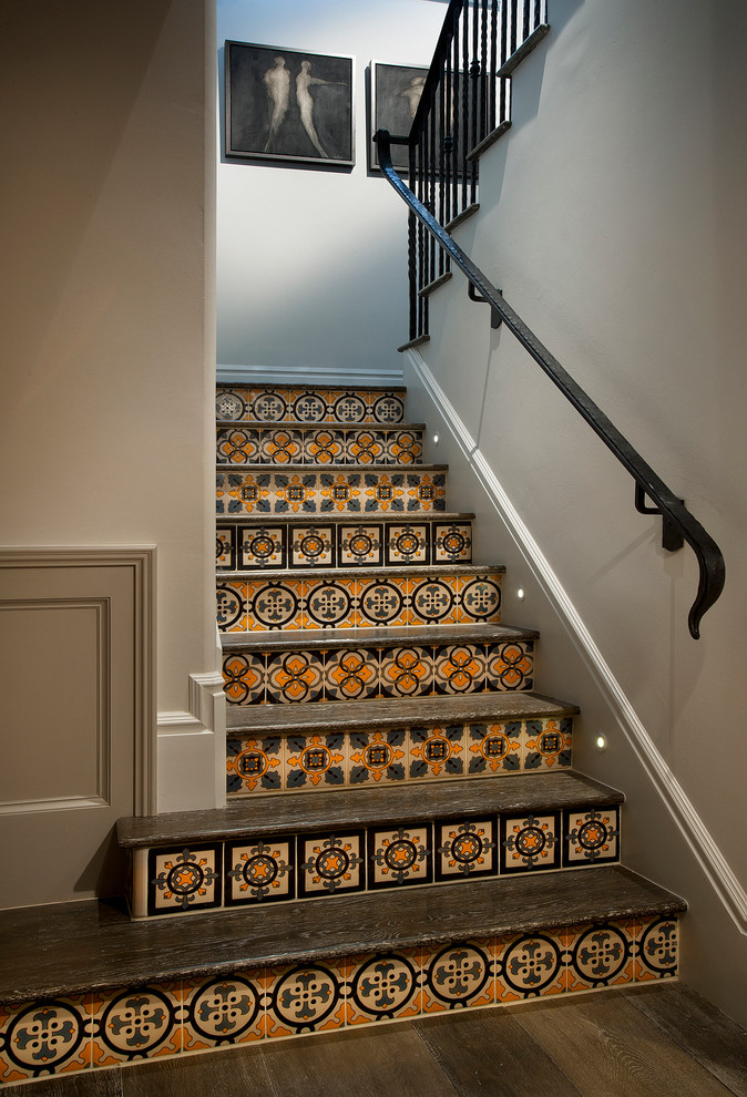 Foto de escalera en L tradicional renovada de tamaño medio con barandilla de metal, escalones de madera y contrahuellas con baldosas y/o azulejos