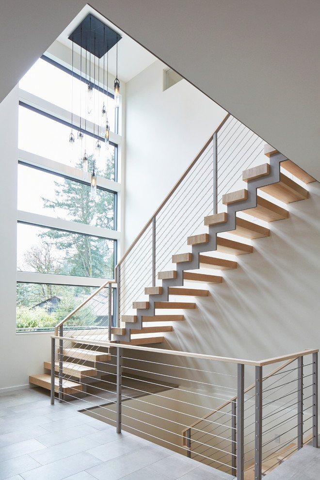 Свежая идея для дизайна: большая лестница на больцах в современном стиле с деревянными ступенями и металлическими перилами без подступенок - отличное фото интерьера
