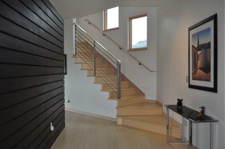 Foto de escalera en L contemporánea de tamaño medio con escalones de madera, barandilla de metal y contrahuellas de madera