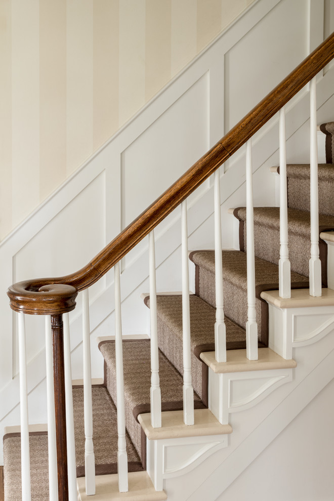 Foto de escalera recta clásica de tamaño medio con escalones enmoquetados, contrahuellas de madera y barandilla de madera