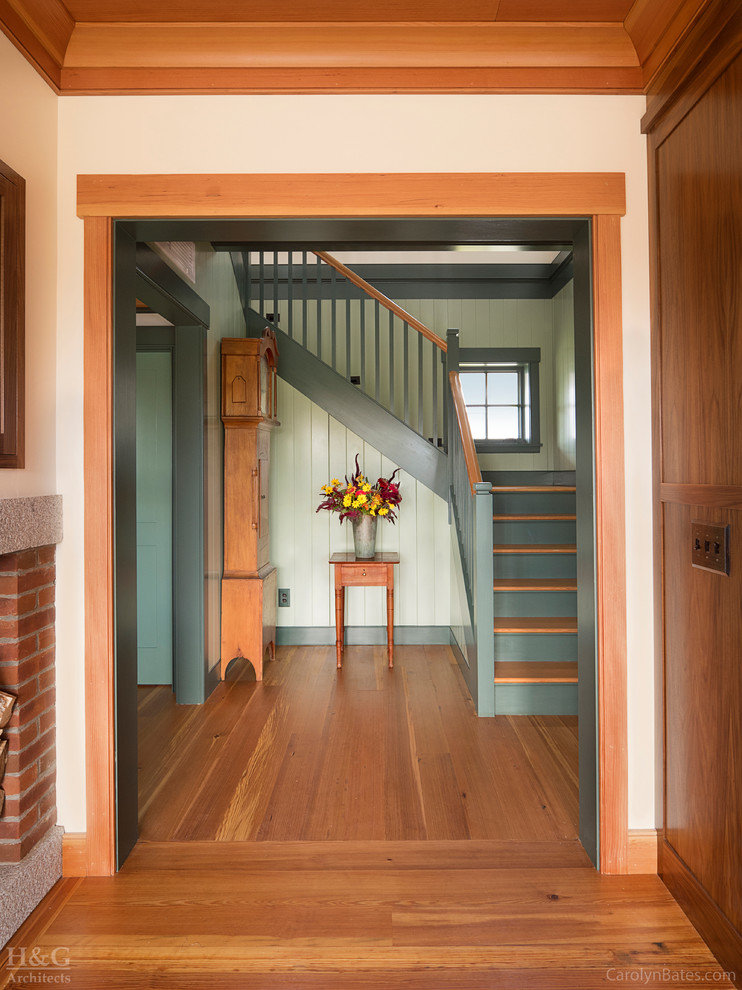 Diseño de escalera en U de estilo de casa de campo de tamaño medio con escalones de madera y contrahuellas de madera pintada