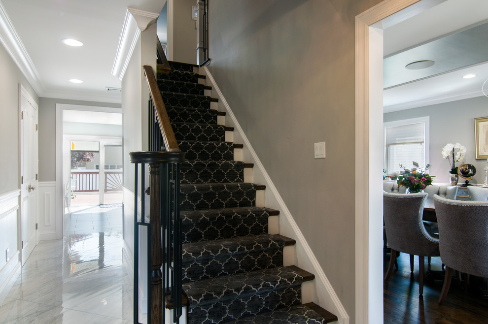 Idées déco pour un grand escalier droit moderne avec des marches en bois, des contremarches en moquette et un garde-corps en métal.