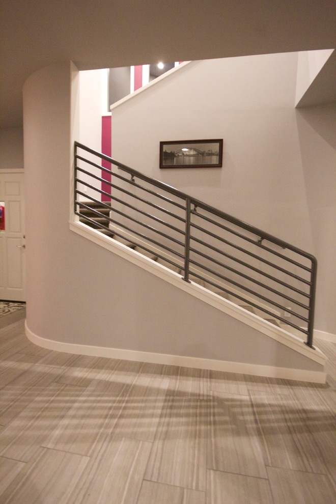 На фото: изогнутая лестница среднего размера в стиле модернизм с ступенями с ковровым покрытием и ковровыми подступенками