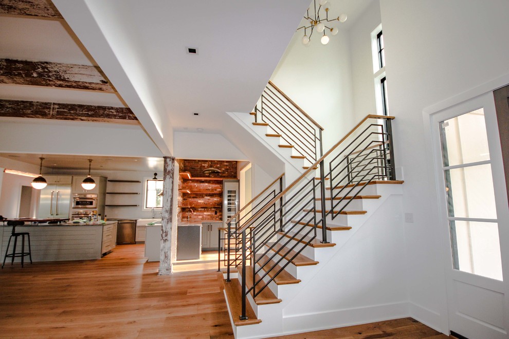Imagen de escalera en U de estilo de casa de campo de tamaño medio con escalones de madera, contrahuellas de madera pintada y barandilla de metal