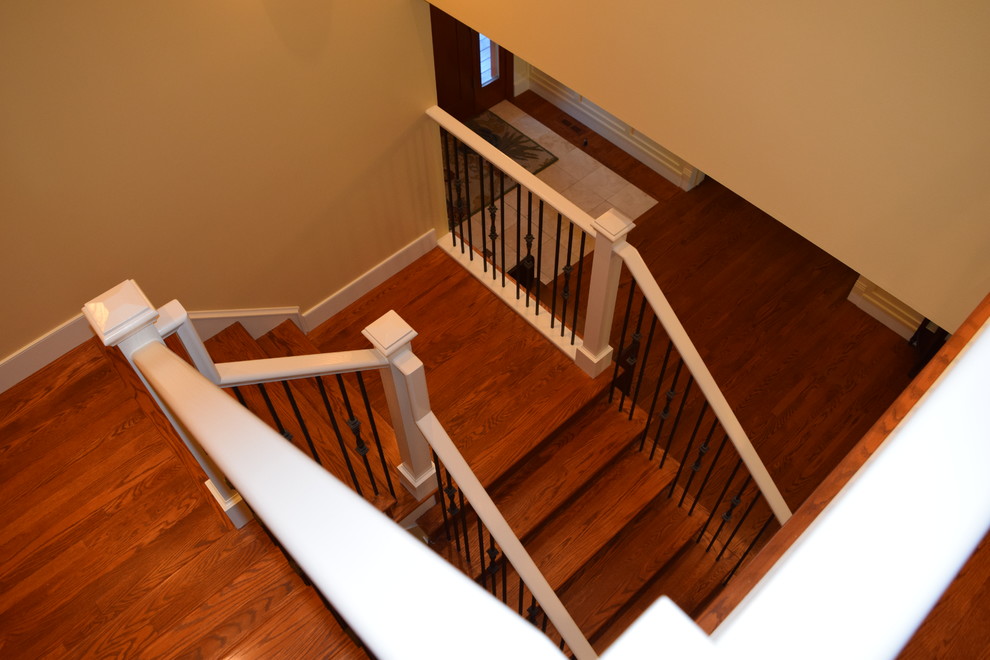 На фото: большая п-образная деревянная лестница в классическом стиле с деревянными ступенями