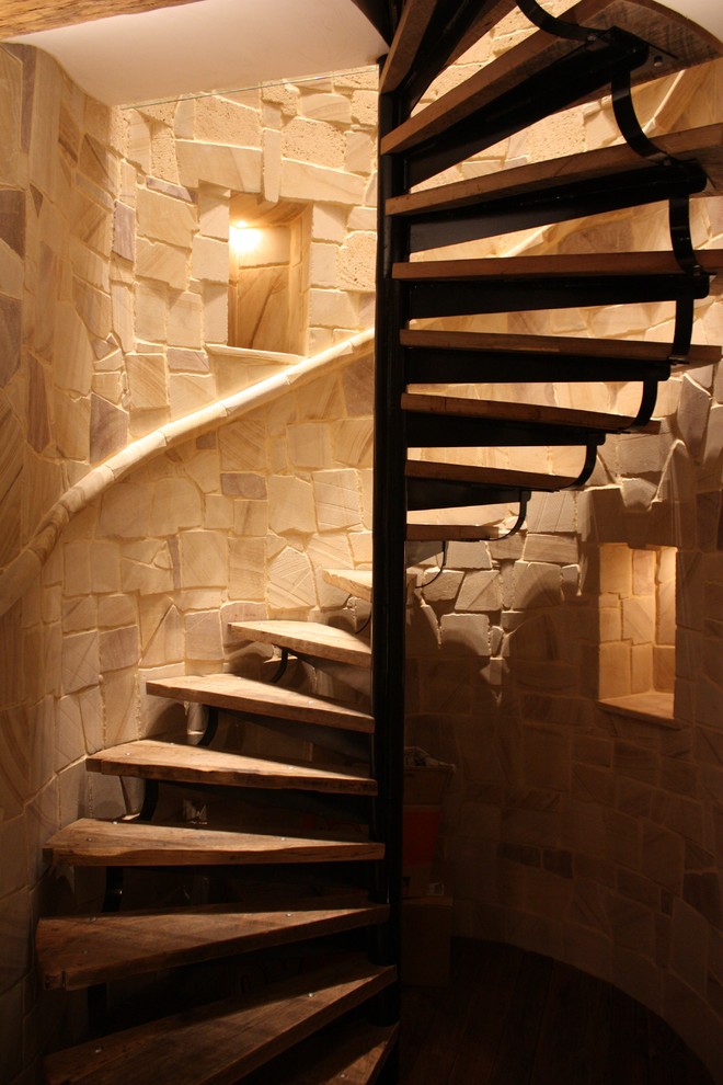 Cette image montre un grand escalier sans contremarche hélicoïdal rustique avec des marches en bois.