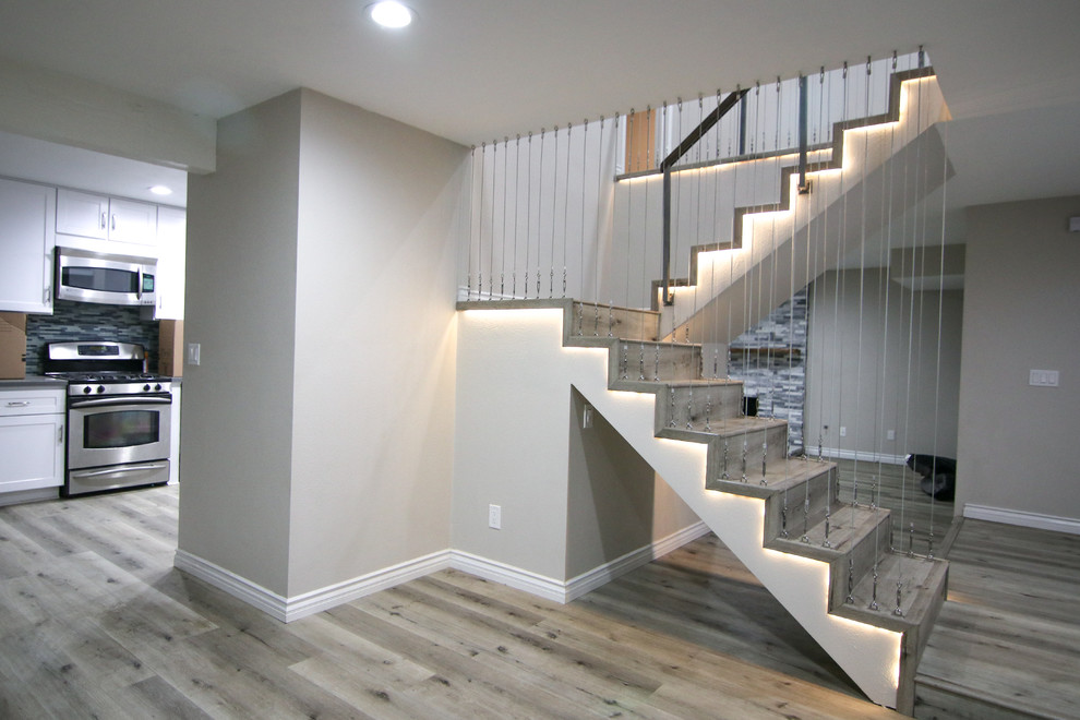 Источник вдохновения для домашнего уюта: п-образная деревянная лестница среднего размера в стиле модернизм с деревянными ступенями и перилами из тросов