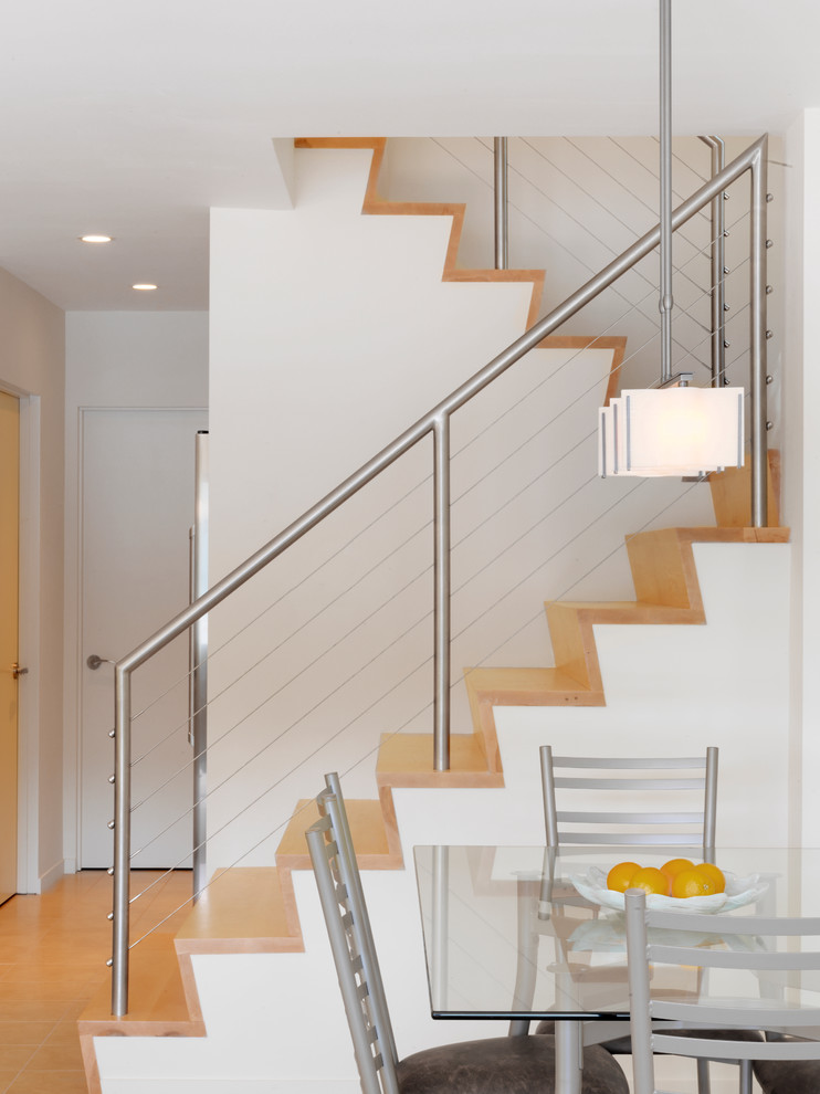 Example of a trendy wooden u-shaped cable railing staircase design in Burlington with wooden risers