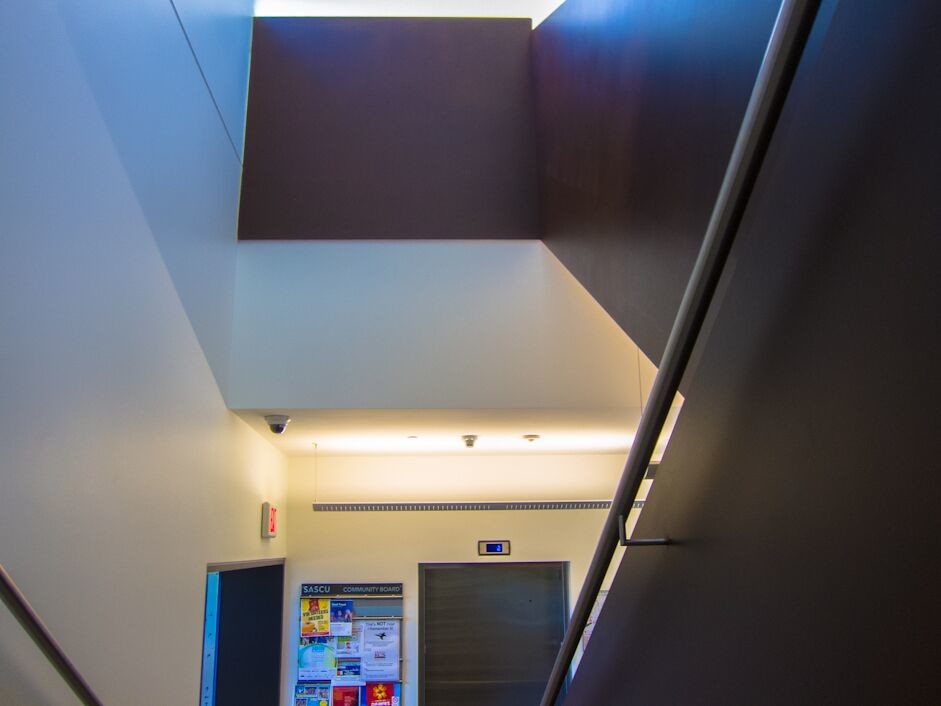 Cette image montre un grand escalier design en U et béton avec des contremarches en métal.