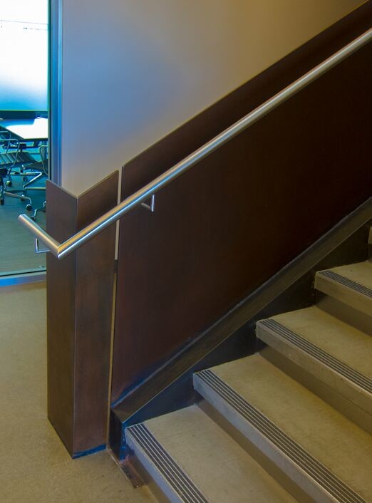 Ejemplo de escalera en U contemporánea grande con escalones de hormigón y contrahuellas de metal