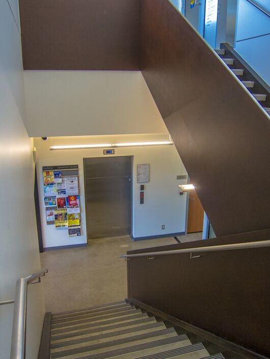 This is an example of a large contemporary concrete u-shaped staircase in Vancouver with metal risers.