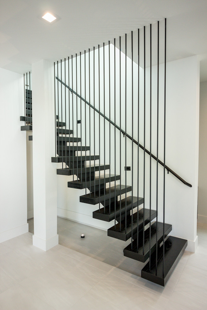 Ejemplo de escalera suspendida minimalista de tamaño medio sin contrahuella con escalones de metal