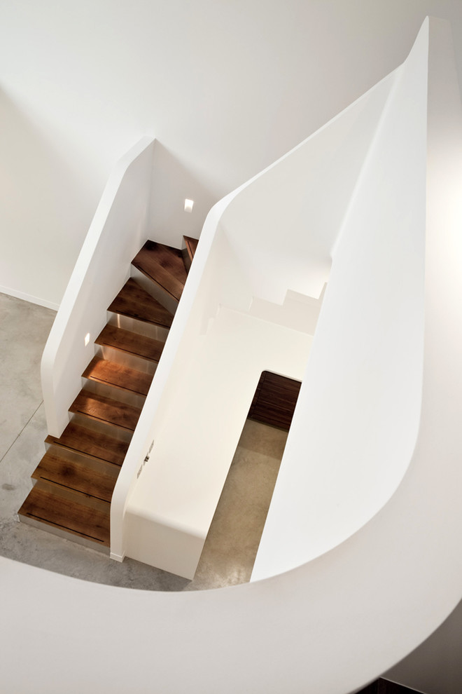 Ejemplo de escalera en L actual de tamaño medio con escalones de madera y contrahuellas de metal