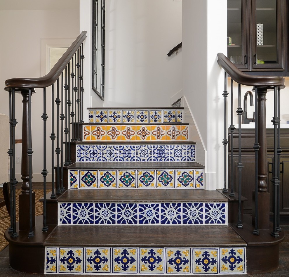 На фото: большая п-образная лестница в средиземноморском стиле с деревянными ступенями и подступенками из плитки с