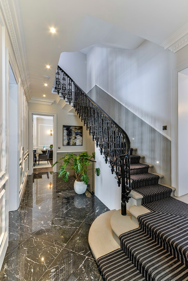 Photo of a large carpeted curved staircase in London.