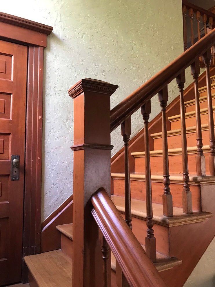 Inspiration for a large victorian wooden l-shaped wood railing staircase remodel in Seattle with wooden risers
