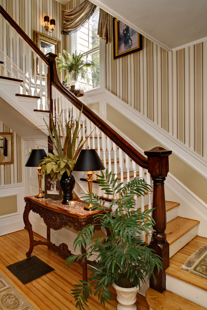 Cette image montre un escalier victorien en L de taille moyenne avec des marches en bois et éclairage.