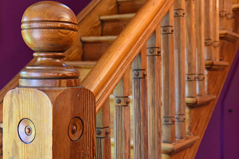 Imagen de escalera en L clásica con escalones de madera, contrahuellas de madera y barandilla de madera