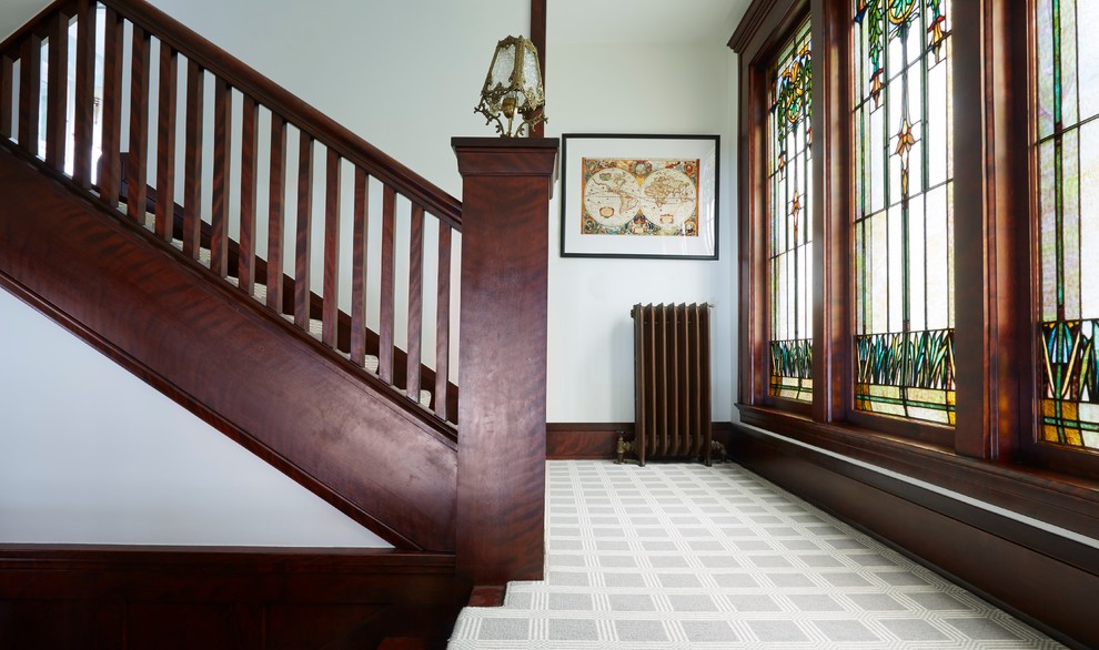 Стильный дизайн: п-образная лестница в стиле неоклассика (современная классика) с ступенями с ковровым покрытием и деревянными перилами - последний тренд