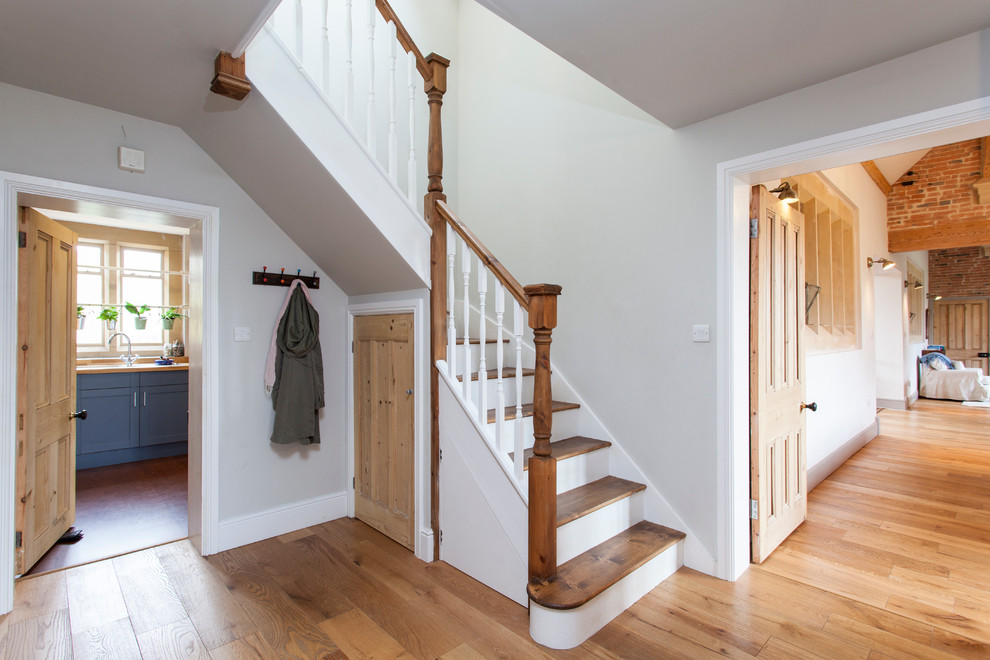 Design ideas for a farmhouse staircase in London with under stair storage.