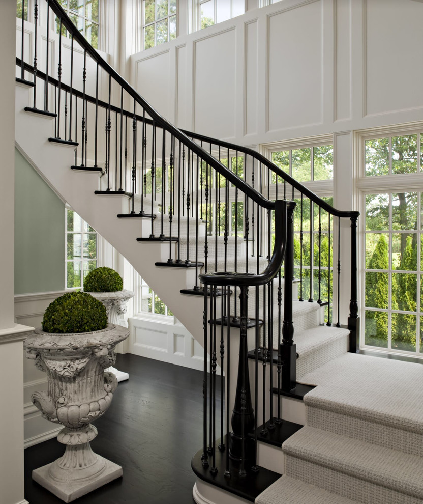 Стильный дизайн: изогнутая лестница в викторианском стиле с деревянными ступенями и крашенными деревянными подступенками - последний тренд