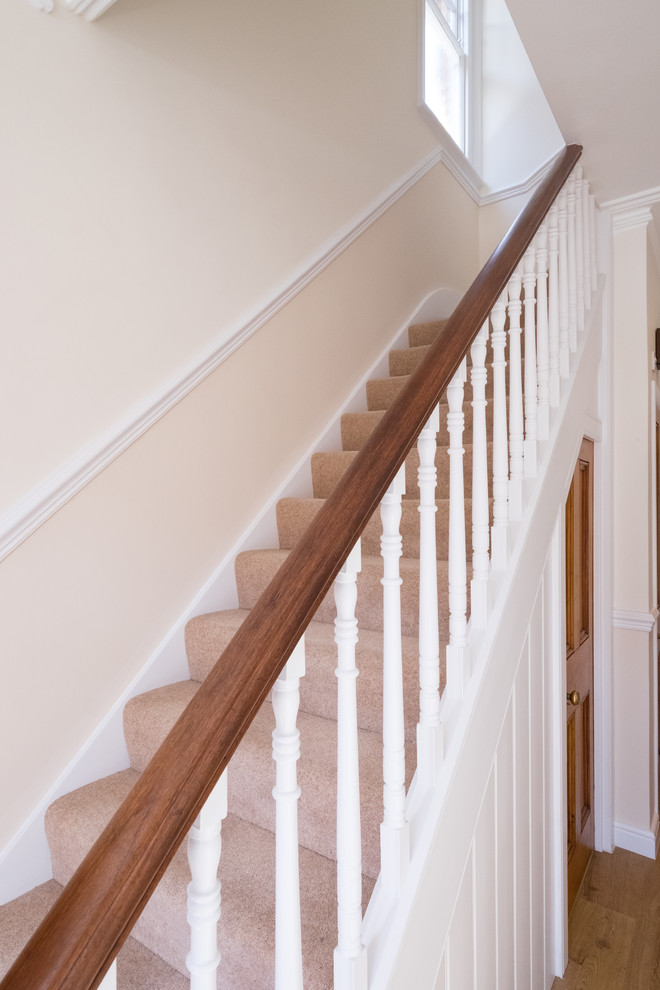 Пример оригинального дизайна: маленькая прямая лестница в классическом стиле с ступенями с ковровым покрытием, ковровыми подступенками и деревянными перилами для на участке и в саду