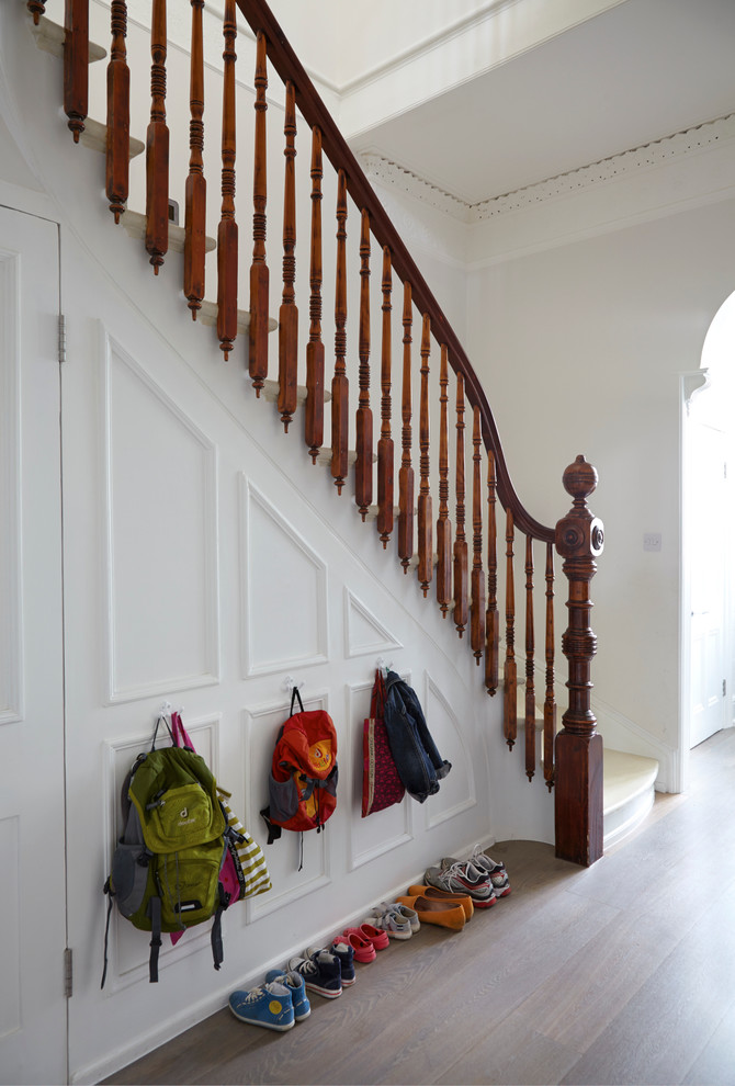 На фото: угловая лестница в викторианском стиле с крашенными деревянными ступенями, крашенными деревянными подступенками и кладовкой или шкафом под ней с