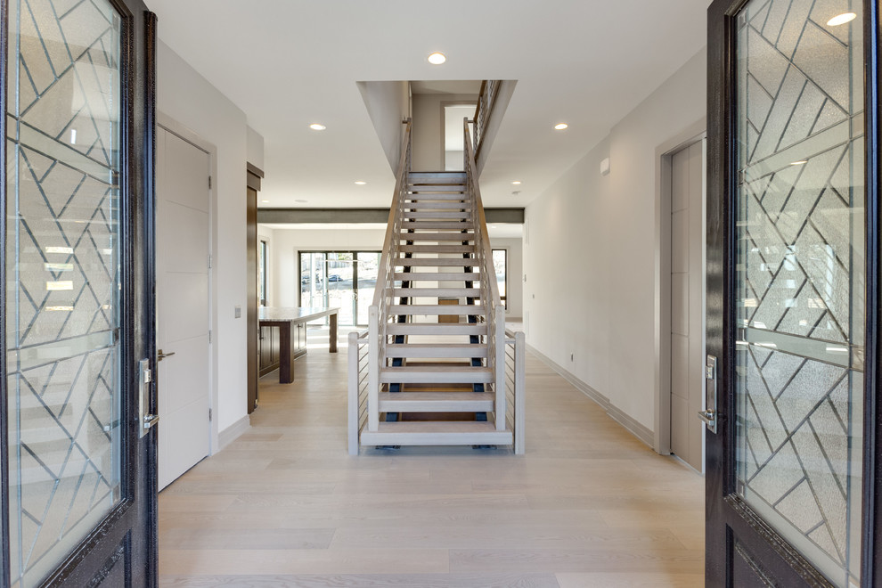 Стильный дизайн: большая металлическая лестница на больцах в стиле модернизм с деревянными ступенями и перилами из смешанных материалов - последний тренд