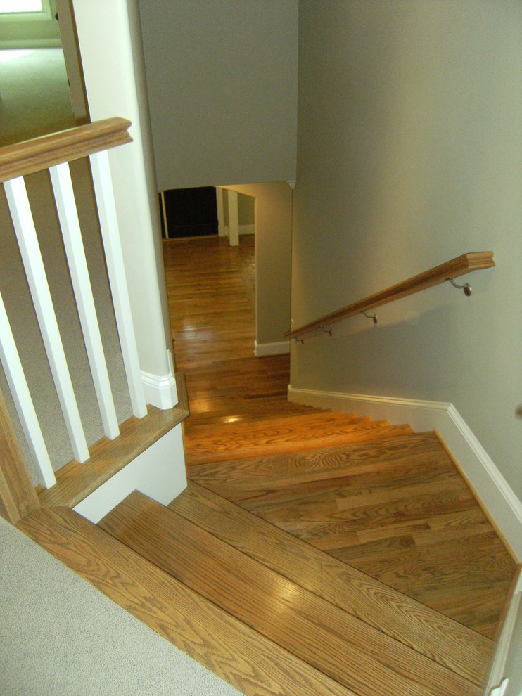 Modelo de escalera en L clásica de tamaño medio con escalones de madera y contrahuellas de madera pintada