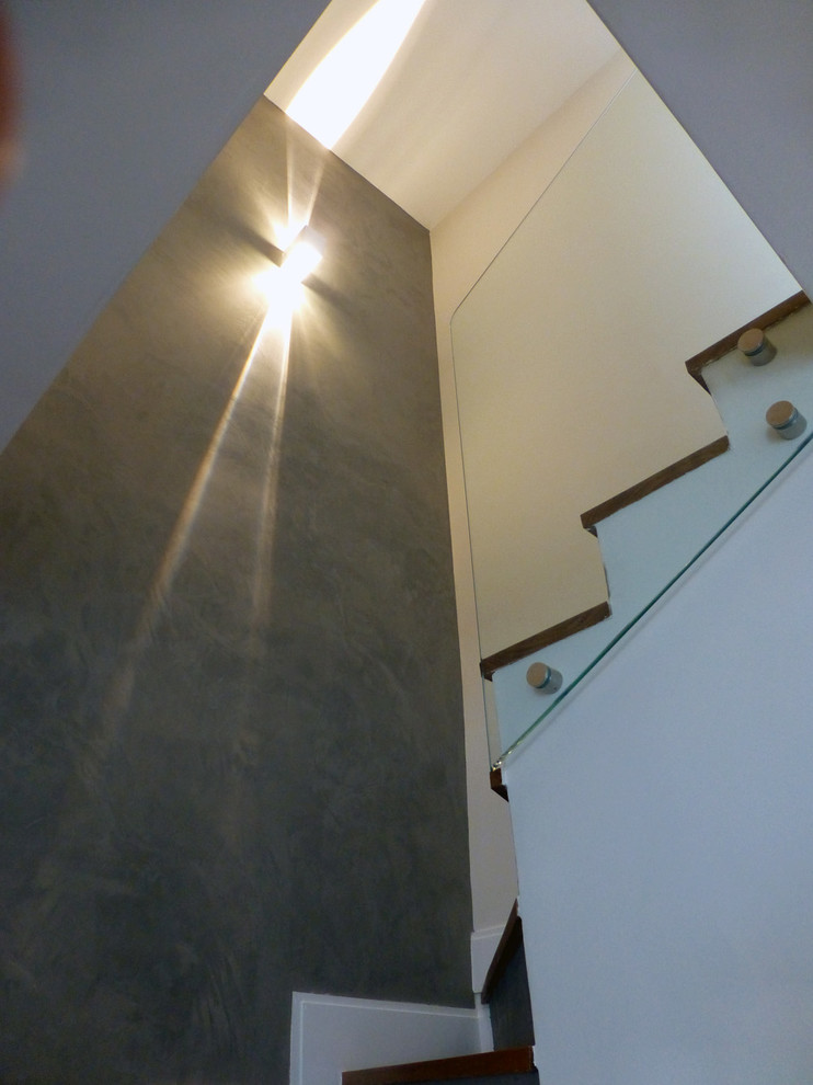 Medium sized contemporary wood u-shaped staircase in Other with concrete risers.