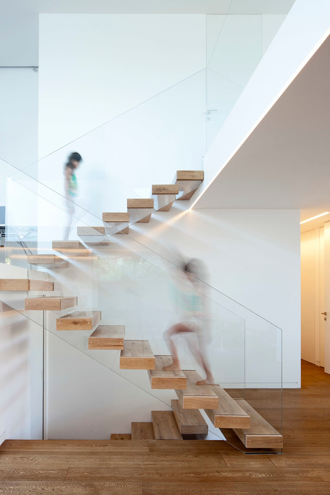 Inspiration pour un escalier flottant minimaliste avec un garde-corps en verre et palier.
