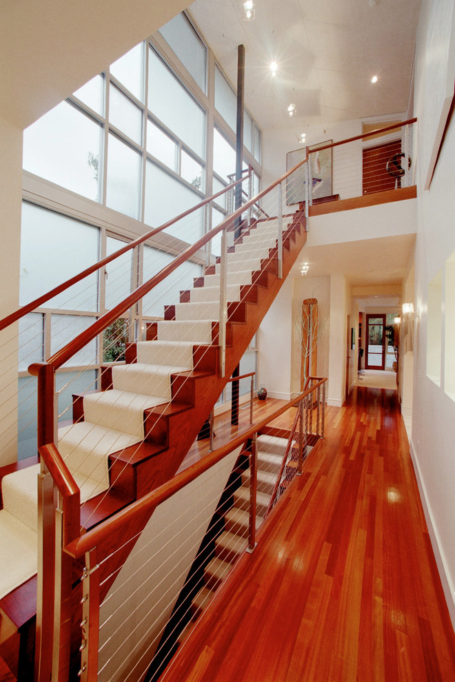 Large modern wood l-shaped staircase in Seattle with wood risers.
