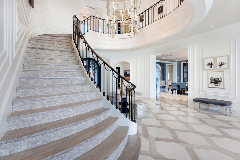 This is an example of an expansive contemporary curved staircase in Miami with tiled risers.