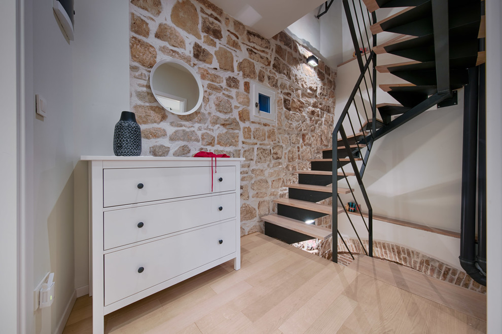 Imagen de escalera en U mediterránea con escalones de madera y barandilla de metal