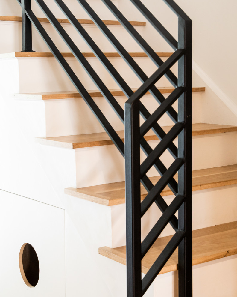На фото: угловая лестница среднего размера в стиле модернизм с деревянными ступенями, крашенными деревянными подступенками и металлическими перилами с