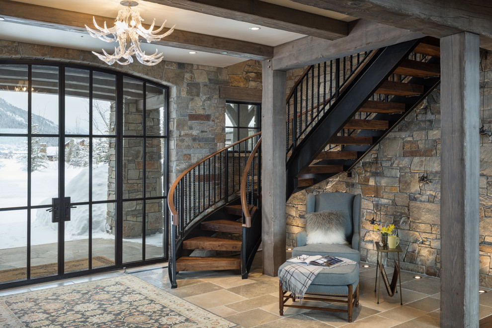 This is an example of a rustic wood curved mixed railing staircase in Jackson with open risers.