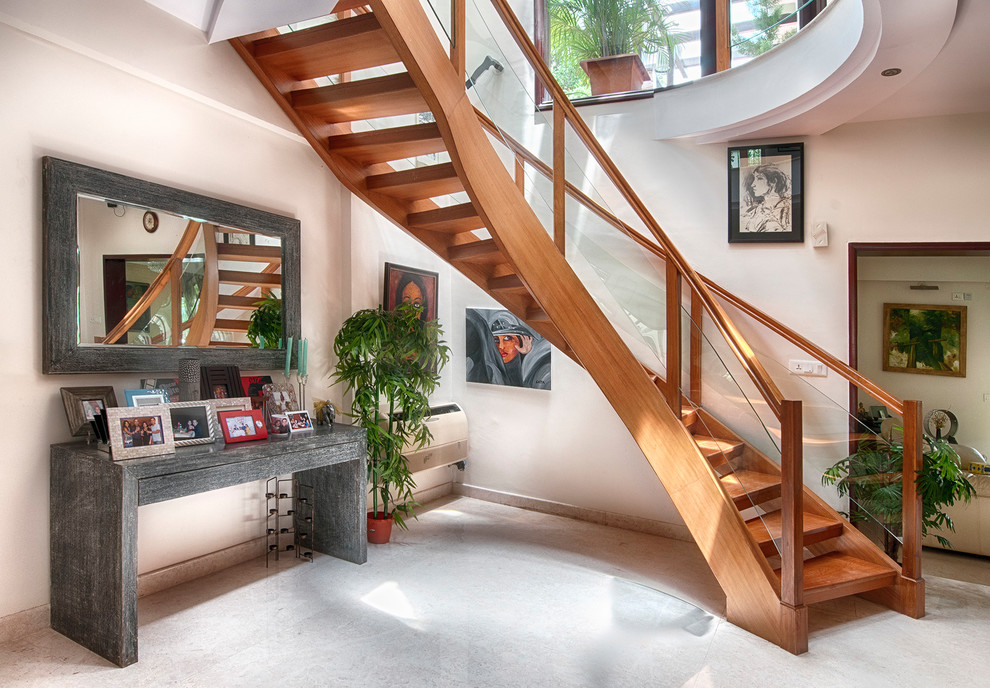 Свежая идея для дизайна: маленькая изогнутая лестница в современном стиле с ступенями из травертина и стеклянными перилами без подступенок для на участке и в саду - отличное фото интерьера