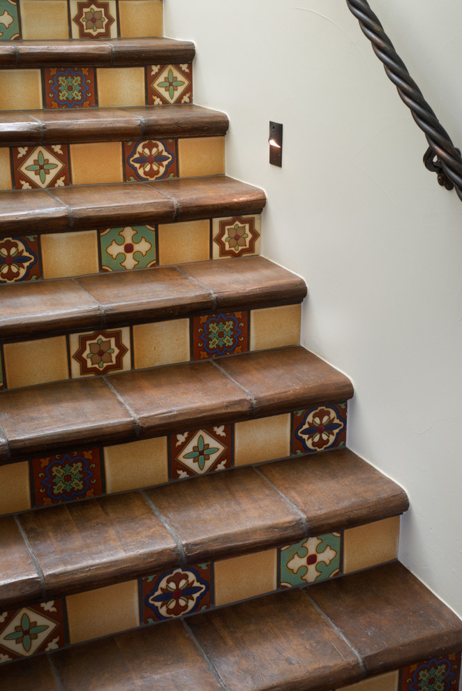 Diseño de escalera en L mediterránea grande con escalones con baldosas y contrahuellas con baldosas y/o azulejos