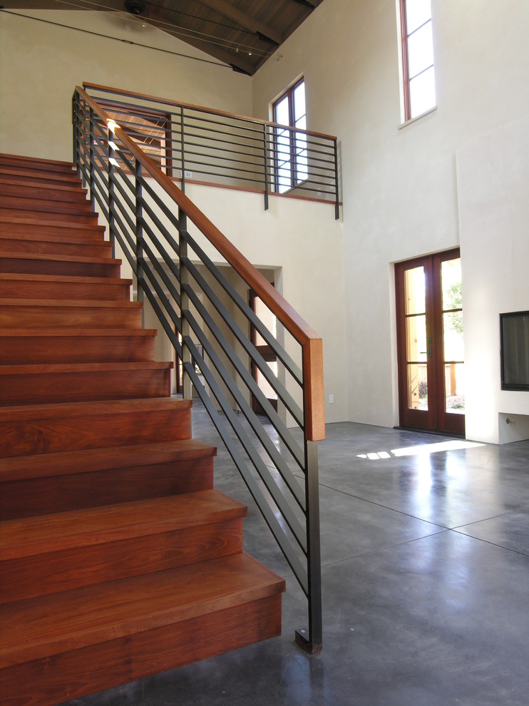 Exemple d'un escalier droit tendance de taille moyenne avec des marches en bois, des contremarches en bois et un garde-corps en métal.