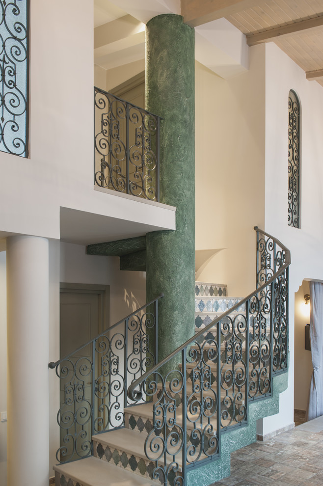 Inspiration for a mid-sized mediterranean wooden curved metal railing staircase remodel in Other with tile risers