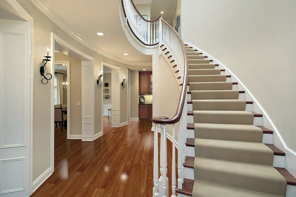 Modelo de escalera curva clásica con escalones de madera y contrahuellas de madera pintada