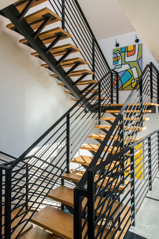 На фото: п-образная лестница в современном стиле с деревянными ступенями и металлическими перилами без подступенок