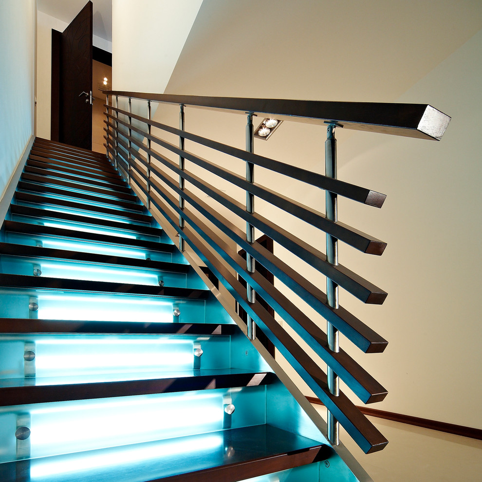На фото: большая прямая лестница в современном стиле с деревянными ступенями и стеклянными подступенками