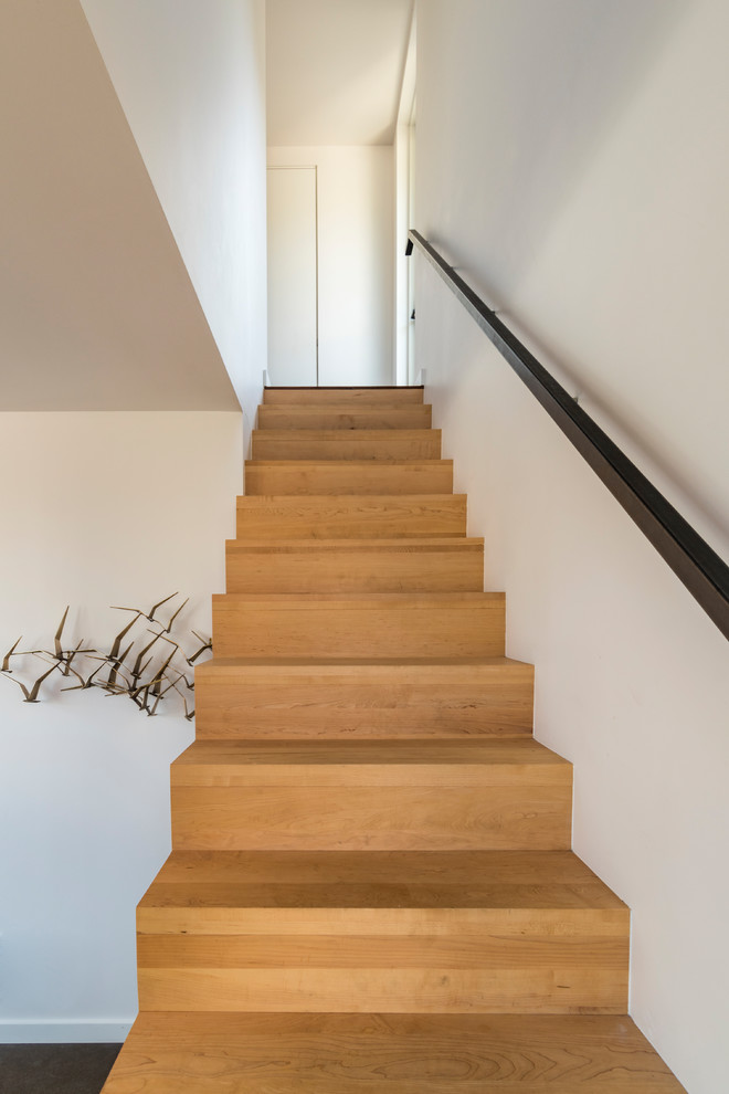 Foto de escalera en L moderna pequeña con escalones de madera, contrahuellas de madera y barandilla de metal