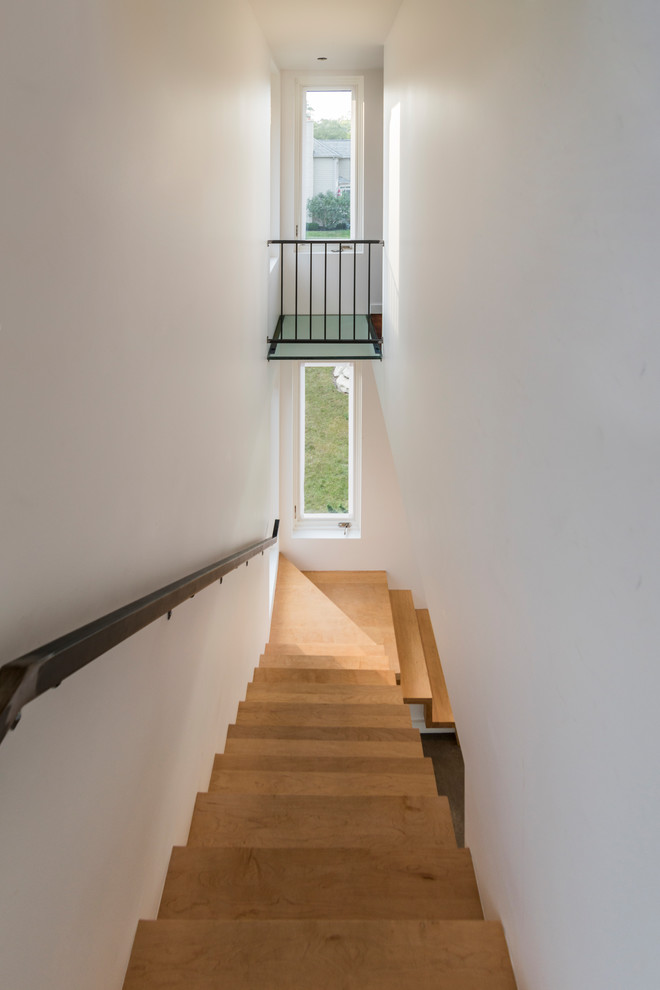 На фото: маленькая угловая деревянная лестница в стиле модернизм с деревянными ступенями и металлическими перилами для на участке и в саду